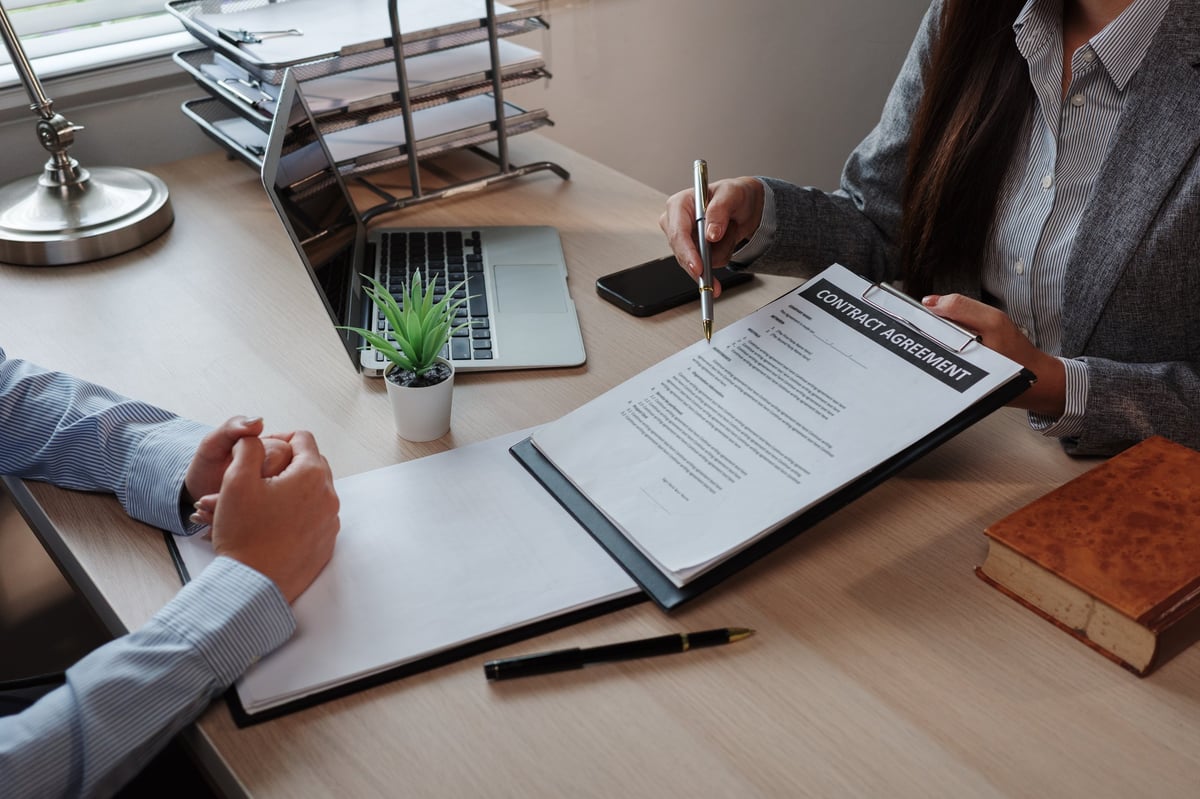 Employer and foreign employee reviewing employment contract for Turkish work permit application and legal compliance requirements