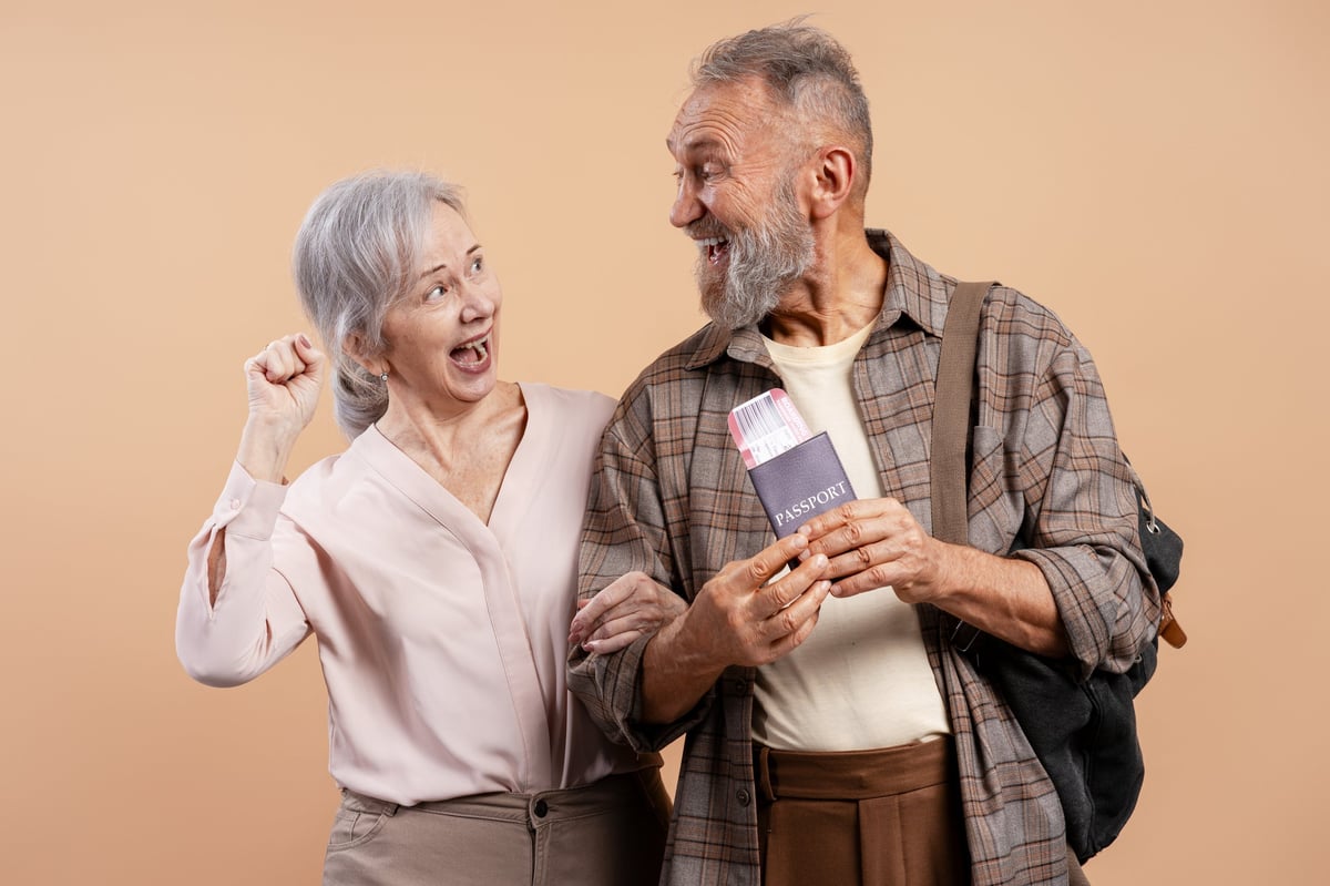 Couple celebrating with travel documents representing Portugal D7 passive income visa and retirement residency in Portugal through stable financial means