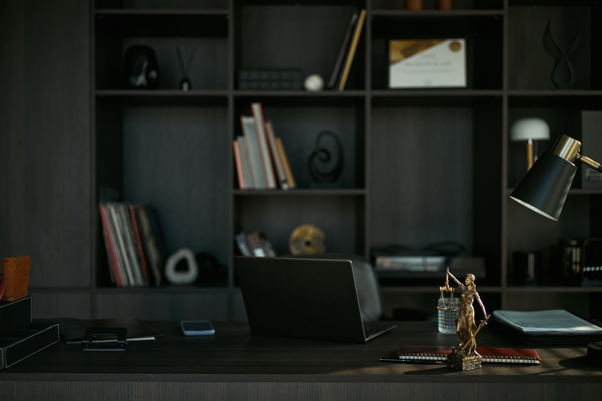 Modern hukuk bürosu çalışma masası, hukuki dosyalar ve Adalet heykeli